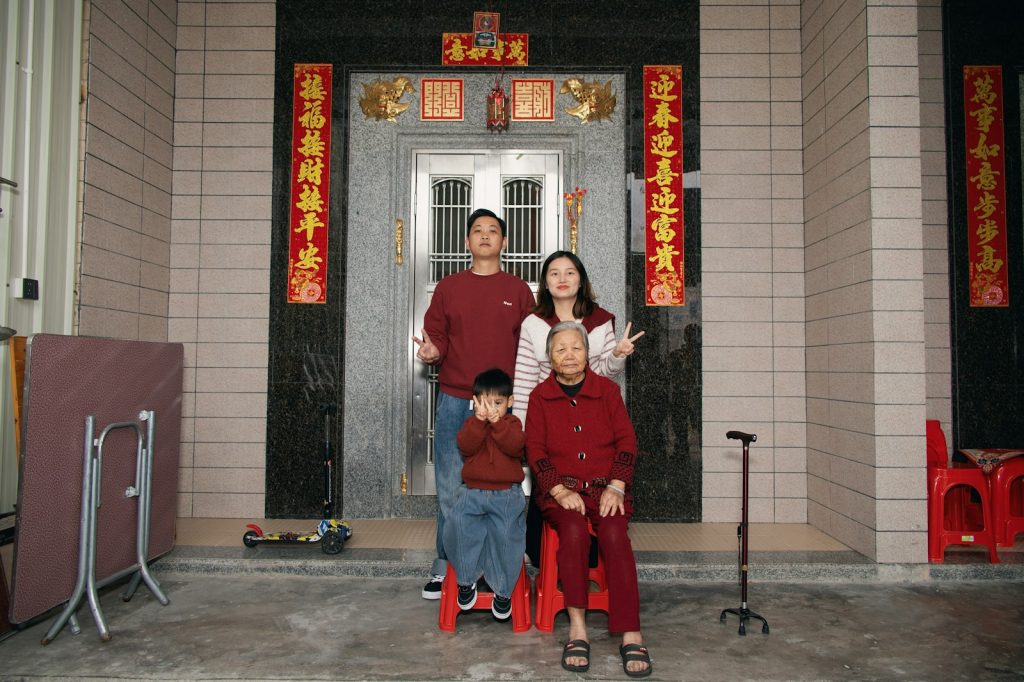 一個東方家族在自家門前合影,象徵失智母親仍記得的家族聲音與身影