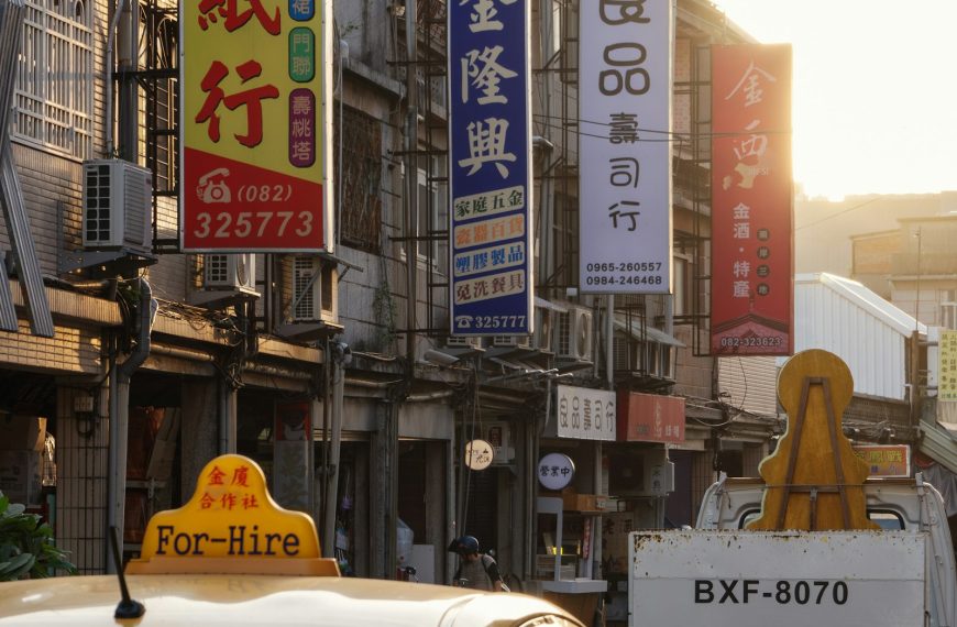 一輛台灣黃色計程車停在街上,背景是和成紙行、金隆興等中文招牌,象徵父親開計程車四十年的台北街景