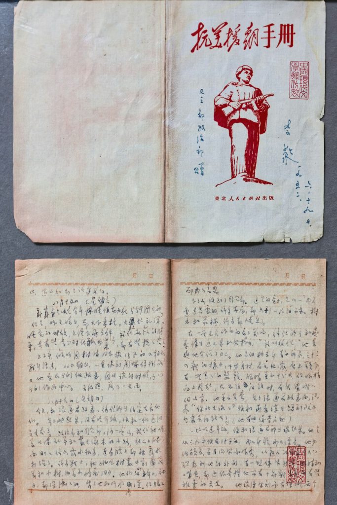 一本紅字封面的中文舊書「抗暴援朝手冊」與手寫筆記頁面，象徵金門時期的軍中歲月與情書