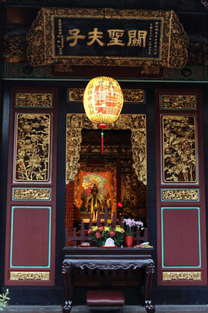 台南關聖夫子廟的紅燈籠與精雕細琢的金漆木門，象徵新人婚禮在台南老廟前的合照場景